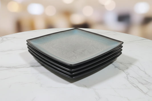 Close-up of a red and blue container with a reflective surface, surrounded by various items.