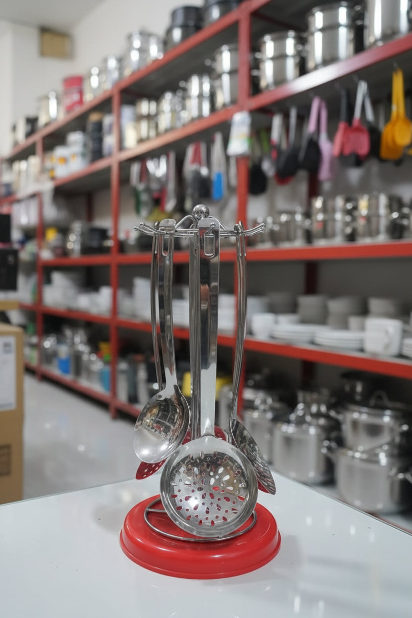 Set of metal kitchen utensils on a red stand with a cluttered background