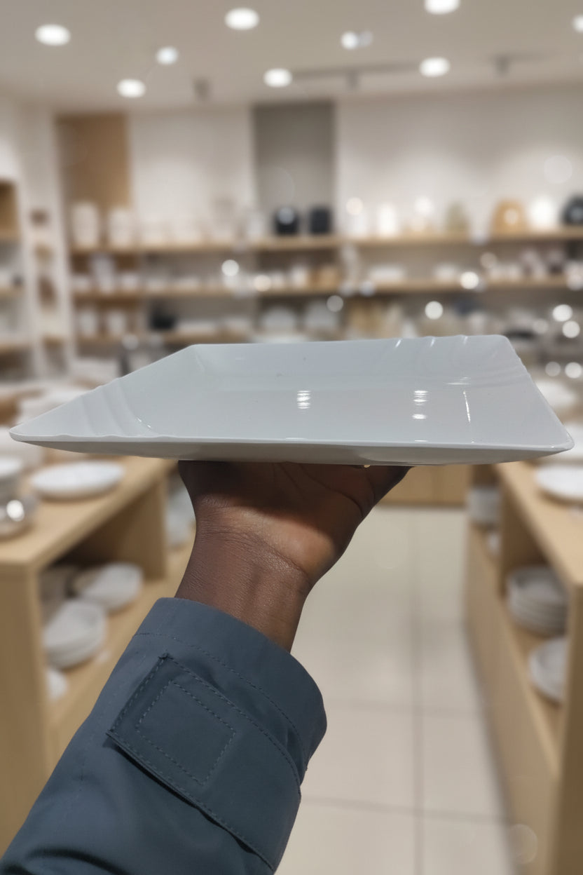 Person holding a white rectangular object in a cluttered workshop setting