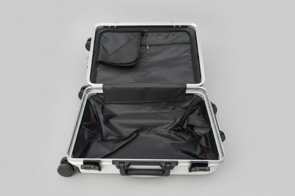 Open black suitcase with wheels on a concrete surface