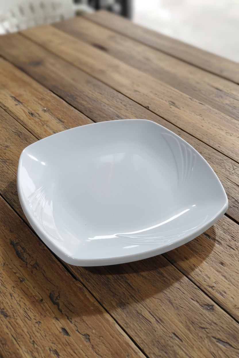 White plastic funnel on a cluttered surface with various items in the background
