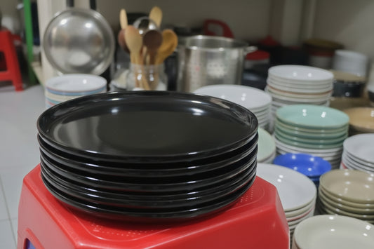 Red stool with a black lid on top in a cluttered indoor setting