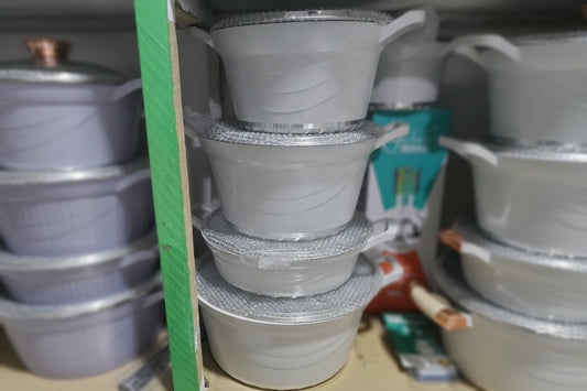 Stack of white metallic containers with metallic interior on a cardboard surface