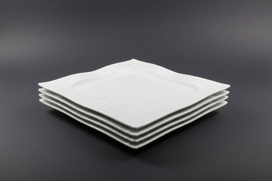 Stack of white square plates on a red stool with a blurred background