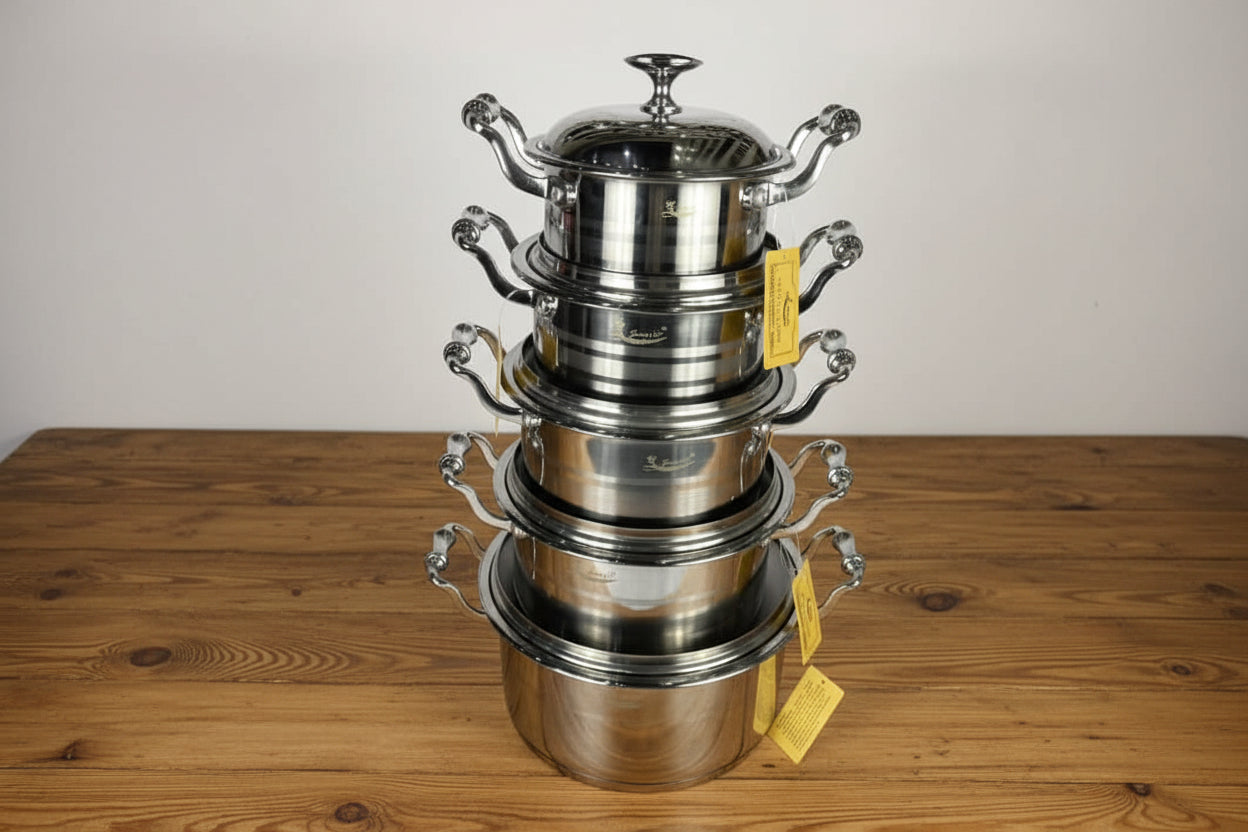 Set of stainless steel pots stacked on a white background