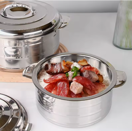 Stainless steel pot with food on a white surface