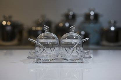 Stack of clear plastic containers with gray speckled lids on a cardboard box.