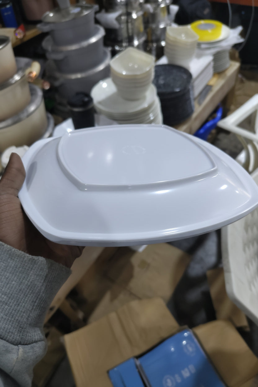 White plastic lid held by a hand with a cluttered background